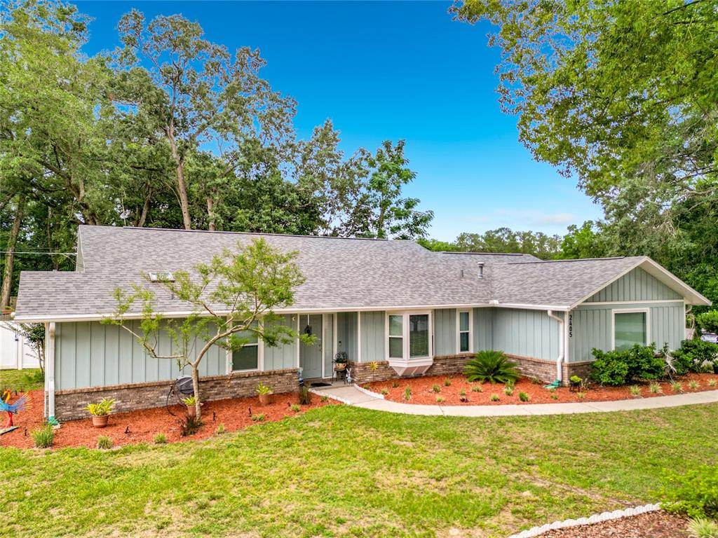 A single-story house with light blue vertical siding, a brick base, and a gray roof — 2405 SE 52ND AVENUE, OCALA, FL