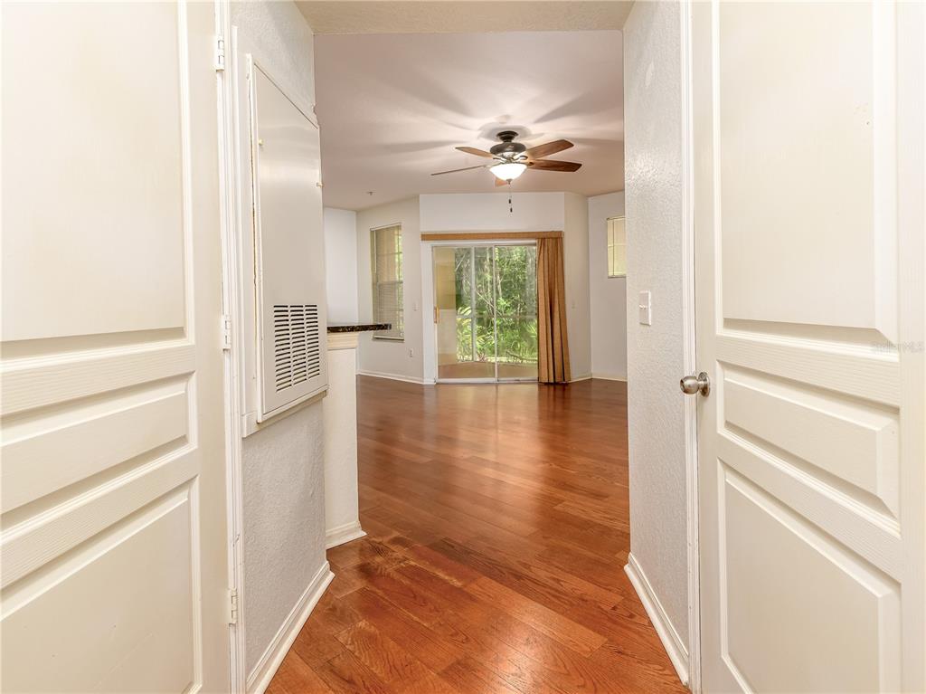 A view through a doorway into a living area with hardwood floors and sliding doors — 5125 PALM SPRINGS BOULEVARD UNIT 7108, TAMPA, FL