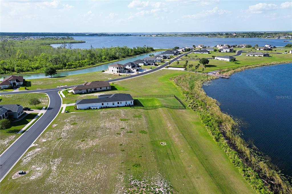An aerial view shows a residential neighborhood with houses situated between two bodies of water — 283 SPINNAKER COURT, AUBURNDALE, FL