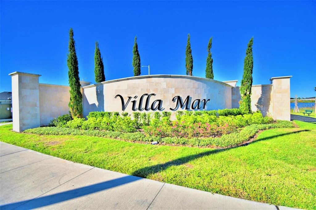 A curved stone monument sign for Villa Mar stands behind a landscaped lawn and trees — 3864 GIORGIO DRIVE, WINTER HAVEN, FL