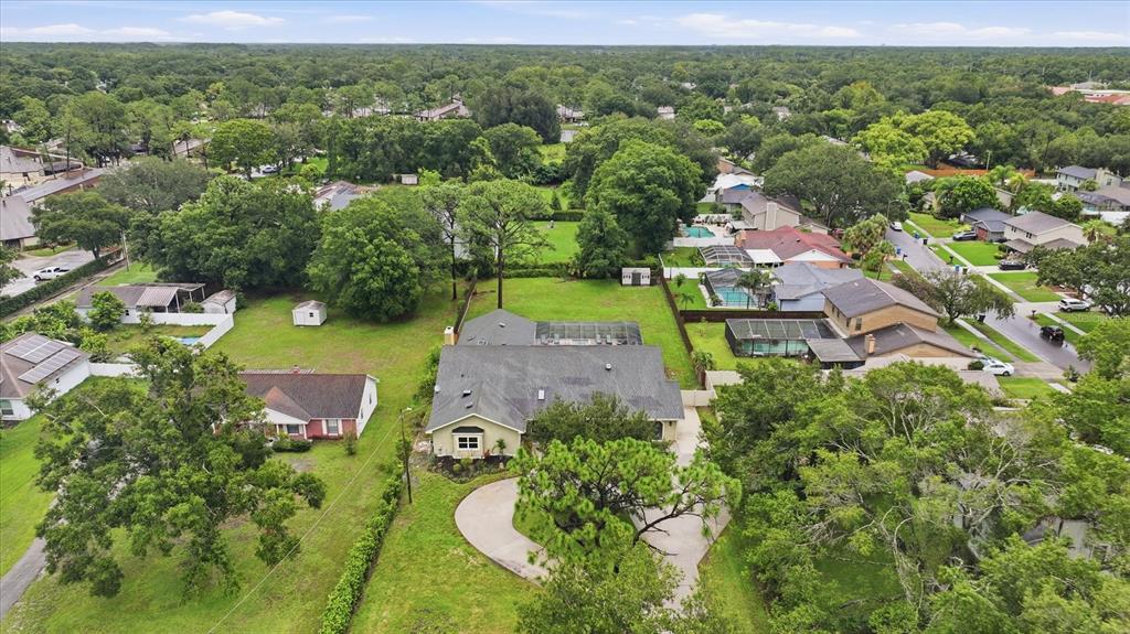 A single-story house with a large tree, a concrete driveway, and a two-car garage — 15127 PENNINGTON ROAD, TAMPA, FL