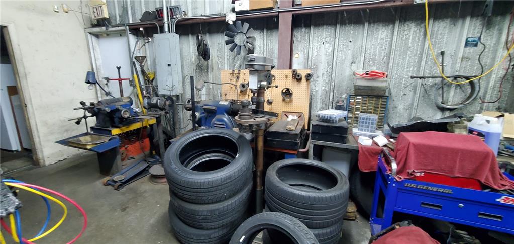 A cluttered workshop features a drill press, stacks of tires, and various tools and equipment — 2714 ORLANDO, SANFORD, FL