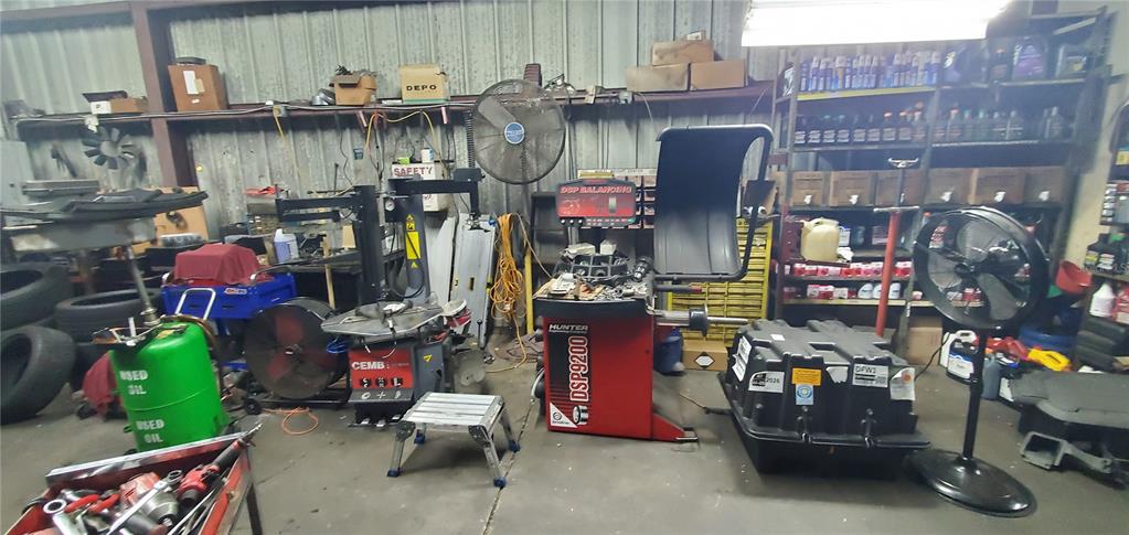 This automotive repair shop features tire changing and balancing equipment, storage shelves, and industrial fans — 2714 ORLANDO, SANFORD, FL
