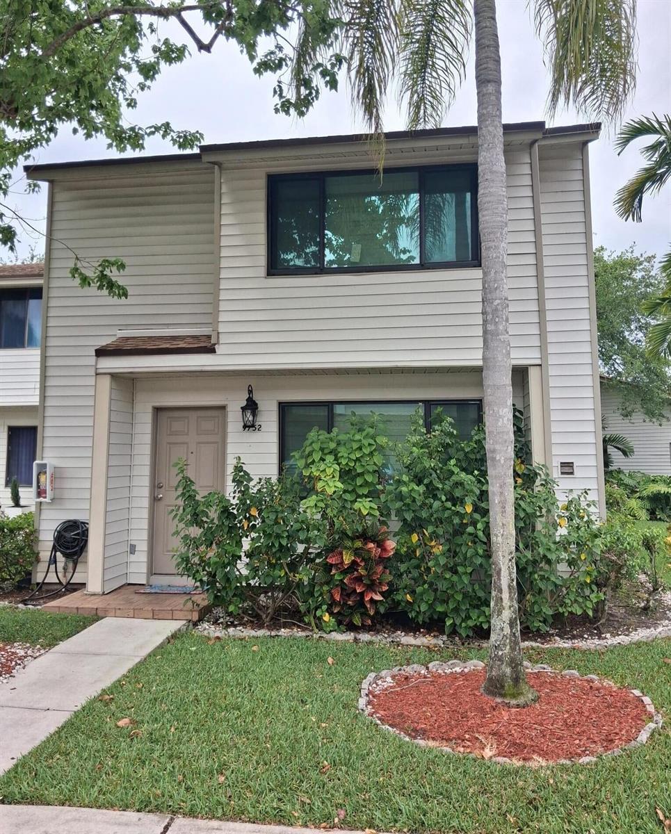 A two-story townhouse with beige siding, a front door, and a landscaped front yard — 9752 NW 37th Street # 7g, Sunrise FL 33351, SUNRISE, FL