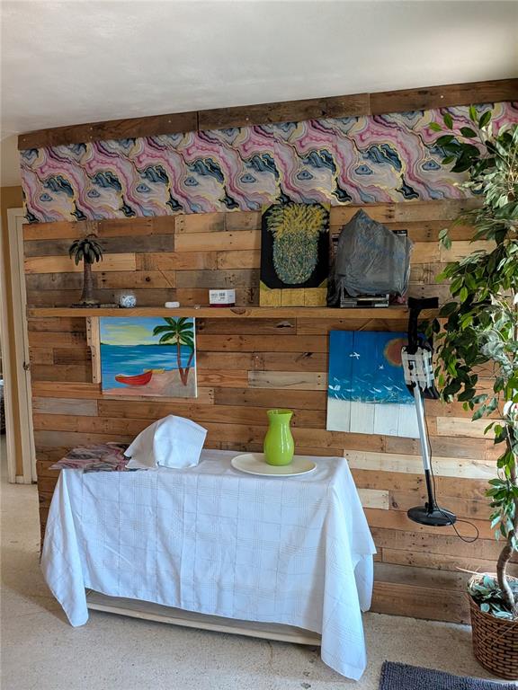 A room features a wood-paneled accent wall, a white-clothed table, and decorative artwork — 2552 LIMEWOOD DRIVE, HOLIDAY, FL