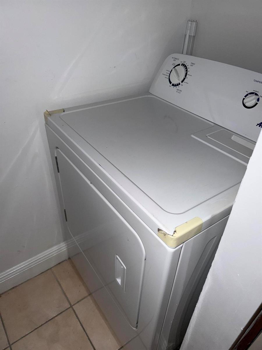 A white clothes dryer sits in a small laundry closet with tiled flooring — 1285 SW 46th Avenue # 2709, Pompano Beach FL 33069, POMPANO BEACH, FL