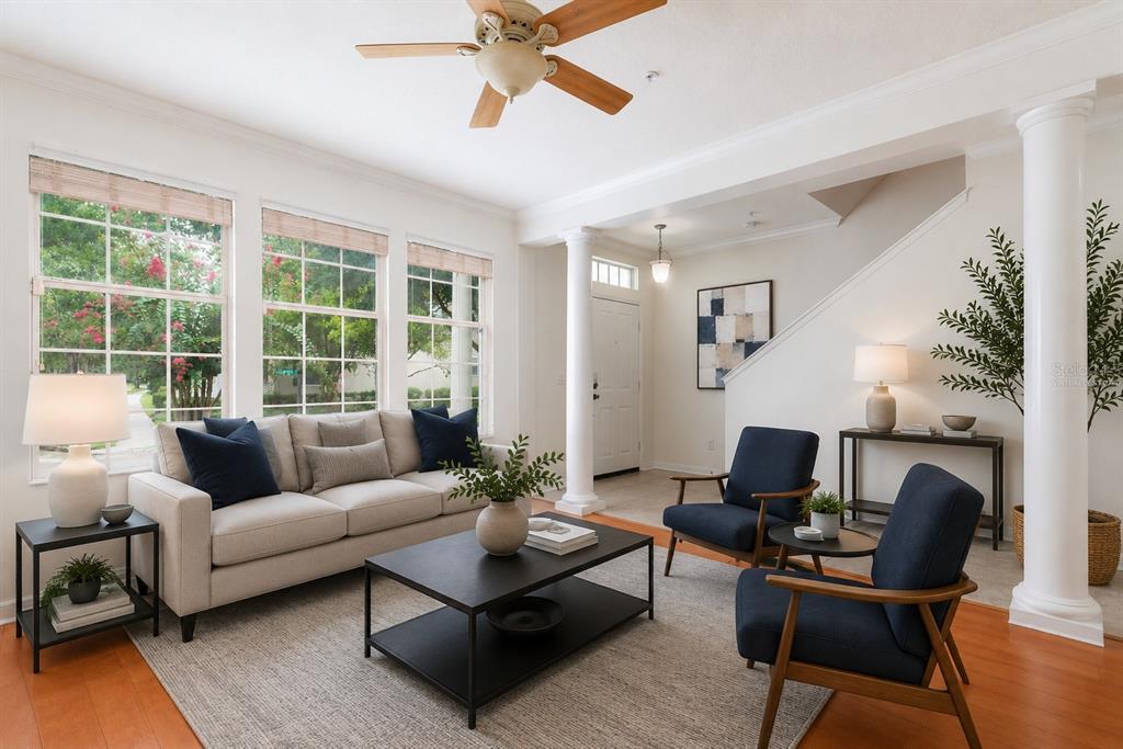 A living room features a beige sofa, two navy armchairs, a coffee table, and white columns — 1003 JUEL STREET, ORLANDO, FL