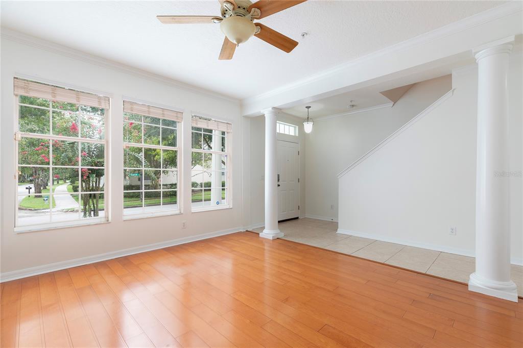 A living room with hardwood floors, large windows, a ceiling fan, and two white columns — 1003 JUEL STREET, ORLANDO, FL
