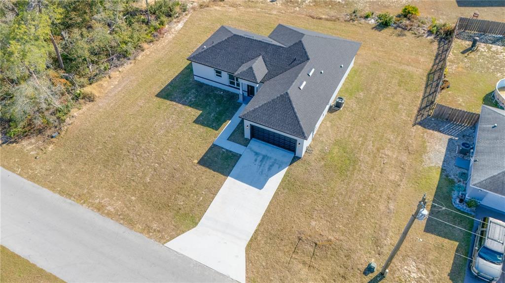 An aerial view shows a single-story house with a dark roof and a concrete driveway — 3110 SW 127TH LANE ROAD, OCALA, FL