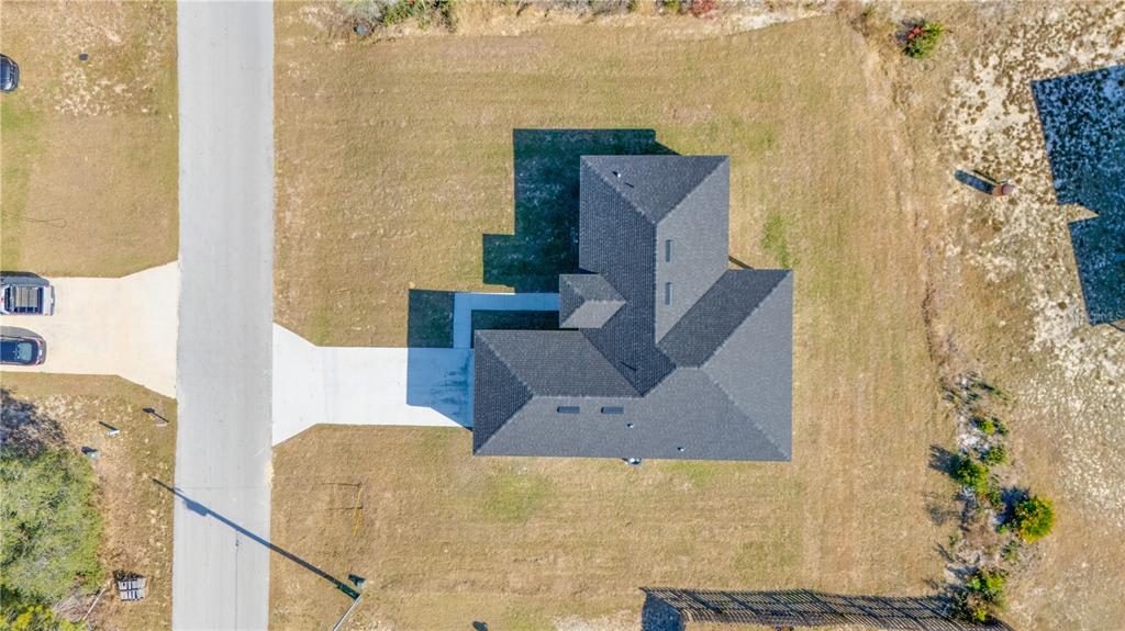 An aerial view shows a house with a dark shingled roof and a concrete driveway — 3110 SW 127TH LANE ROAD, OCALA, FL