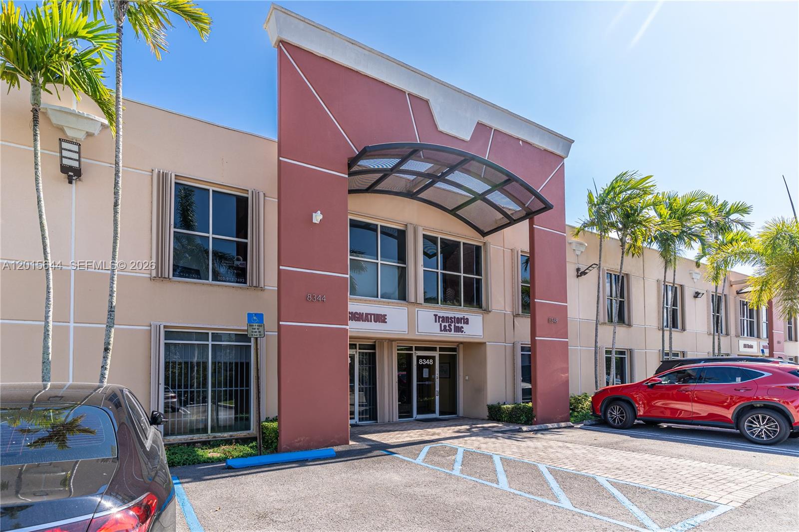A two-story commercial building features a red central entrance with a curved metal awning — 8344 NW 30th Ter, Doral FL 33122, DORAL, FL