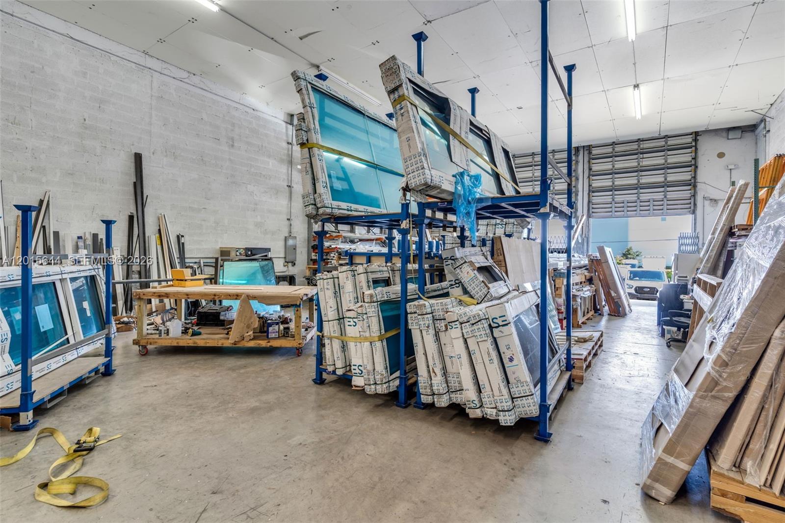 This industrial warehouse space features metal storage racks filled with glass windows and doors — 8344 NW 30th Ter, Doral FL 33122, DORAL, FL