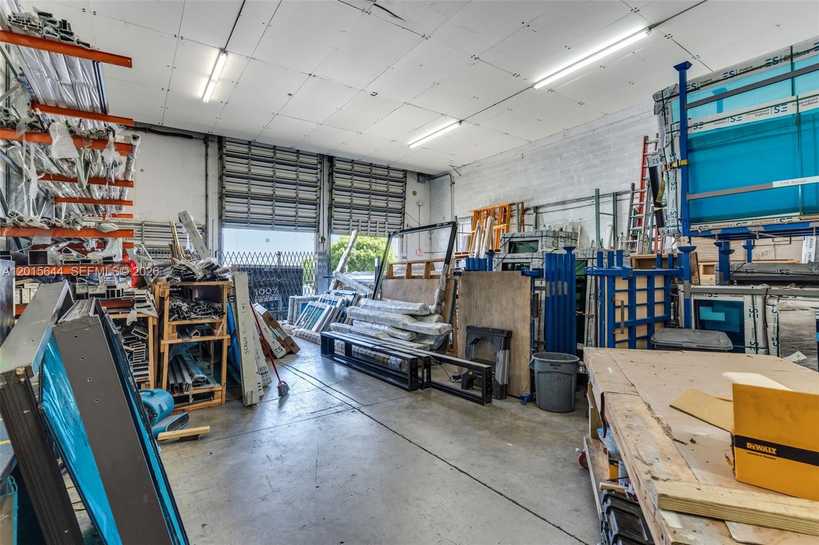 A warehouse interior features concrete floors, high ceilings with fluorescent lights, and various industrial storage racks — 8344 NW 30th Ter, Doral FL 33122, DORAL, FL