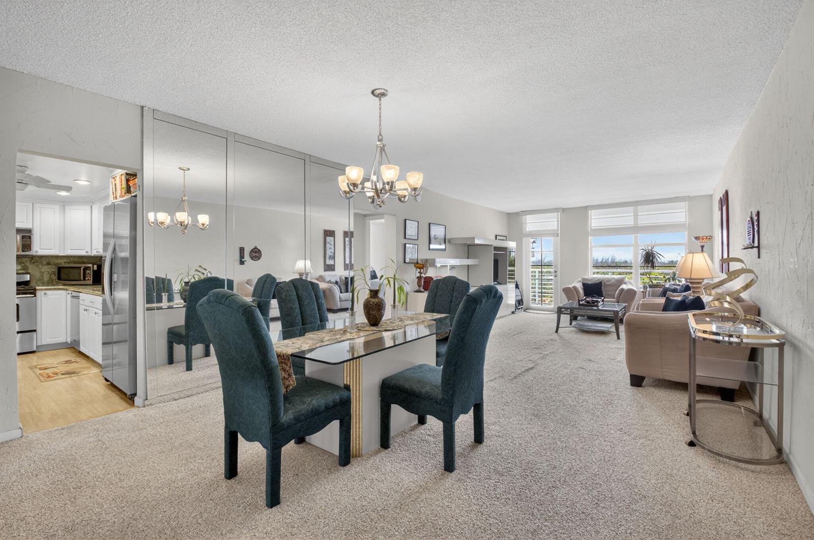 A dining area with a glass table and blue chairs sits before a mirrored wall — 2851 S Ocean Boulevard # 5m, Boca Raton FL 33432, BOCA RATON, FL