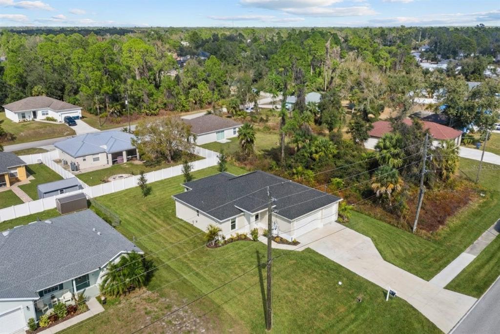 An aerial view shows a suburban house with a dark roof and a concrete driveway — 2711 ATWATER DRIVE, NORTH PORT, FL