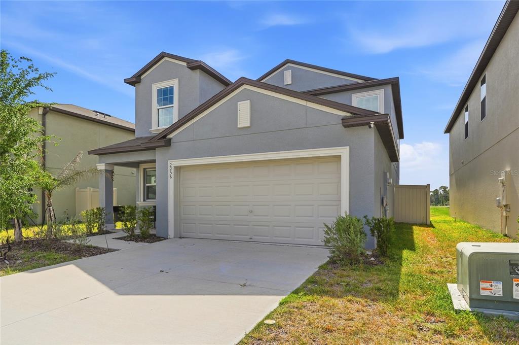 A two-story gray stucco house with a two-car garage and a concrete driveway — 2256 TENEROC TRAIL, LAKELAND, FL