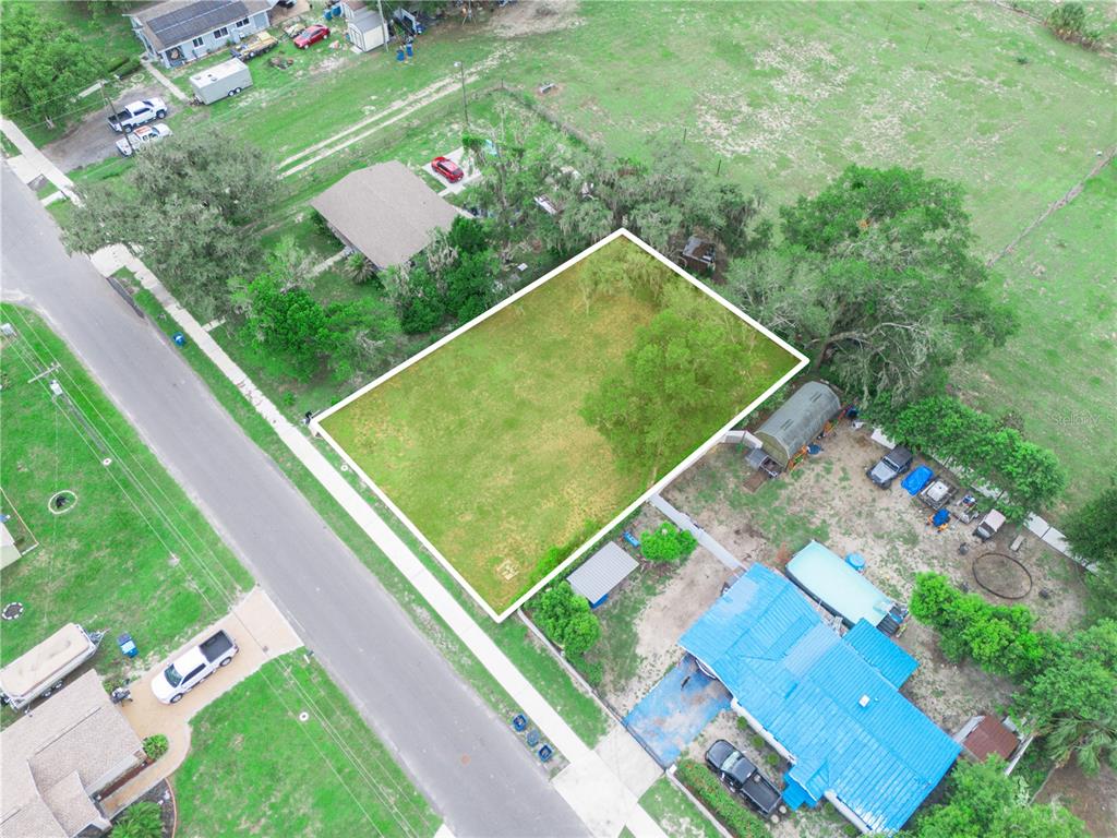 An aerial view shows a vacant rectangular lot bordered by a road and neighboring houses — 314 SE 3RD STREET, FORT MEADE, FL