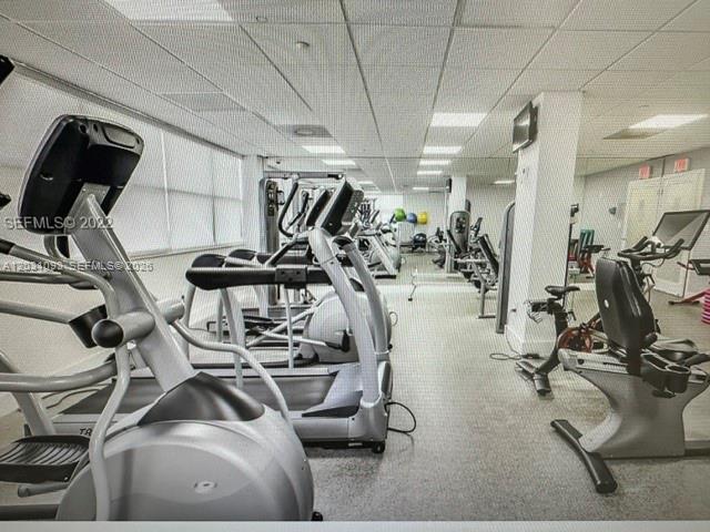 A gym room features multiple treadmills, stationary bikes, and exercise balls on a carpeted floor — 1420 Brickell Bay Dr # 1107C, Miami FL 33131, MIAMI, FL