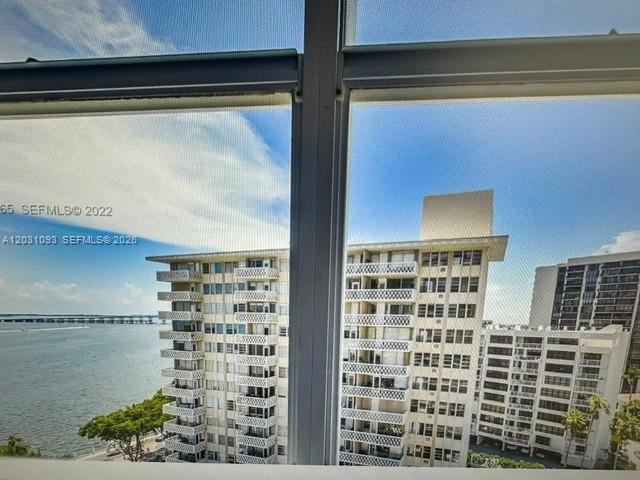 A view from a window shows multiple high-rise apartment buildings overlooking a body of water — 1420 Brickell Bay Dr # 1107C, Miami FL 33131, MIAMI, FL
