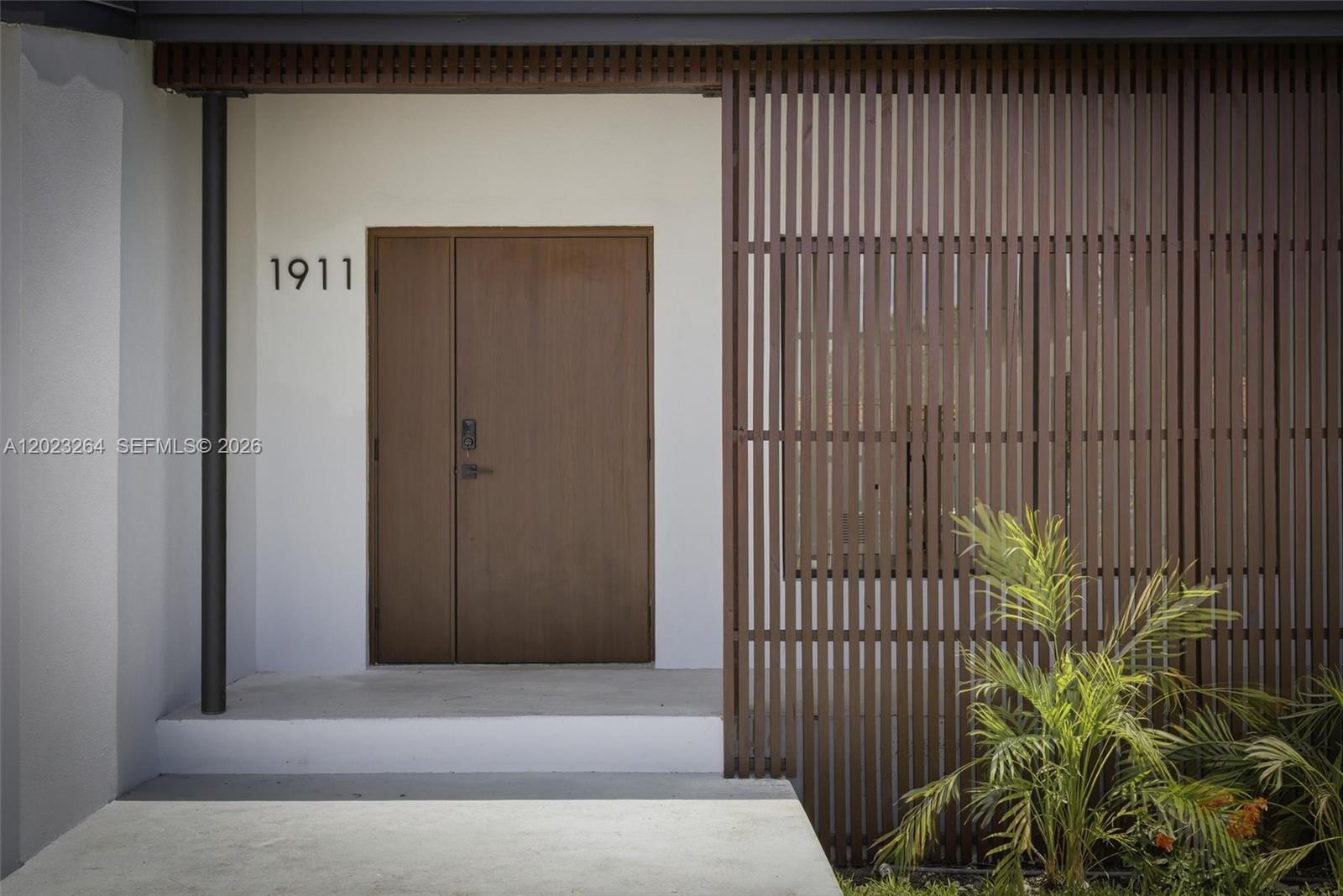 A modern entryway features a brown door, house number 1911, and a vertical wood slat screen — 1911 SW 18th Ave, Miami FL 33145, MIAMI, FL
