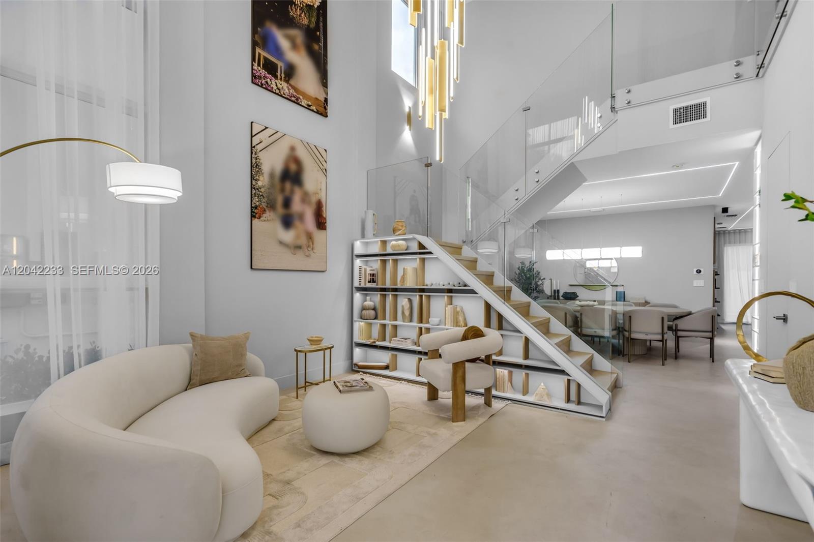 A modern living room features a curved sofa, open staircase shelving, and a glass railing — 7533 NW 98th Ct, Doral FL 33178, DORAL, FL