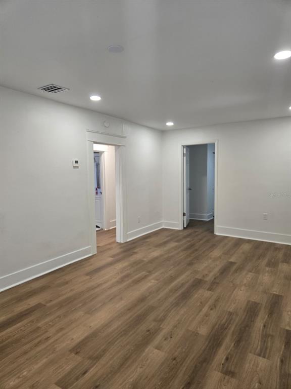 An interior view of a room with white walls, recessed lighting, and wood-look flooring — 709 E JAMES STREET, TAMPA, FL