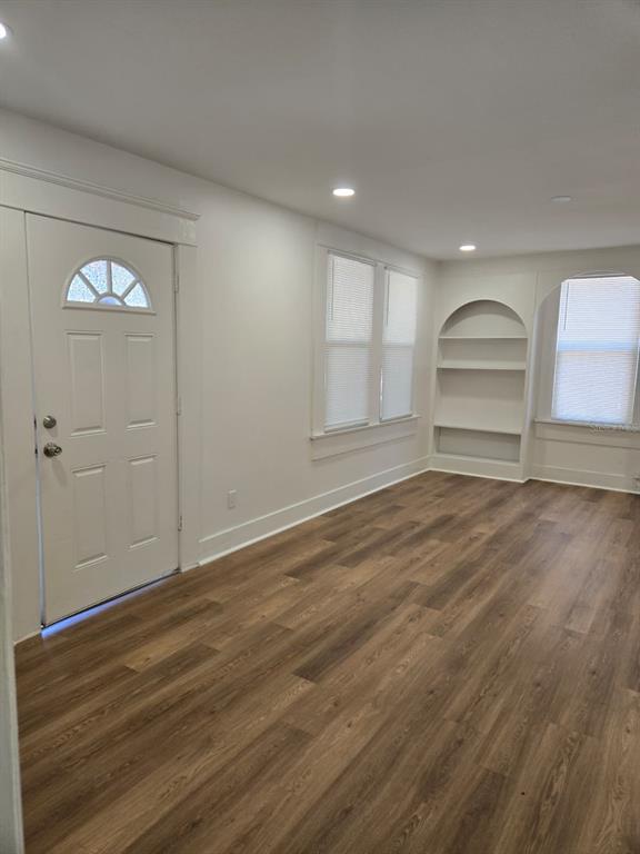 A room with wood-look flooring, white walls, a front door, and built-in arched shelving — 709 E JAMES STREET, TAMPA, FL