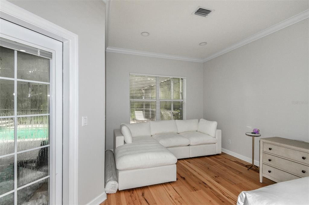 A room with light gray walls, hardwood floors, a white sectional sofa, and a glass door — 1350 N CIRCUS TERRACE, HERNANDO, FL