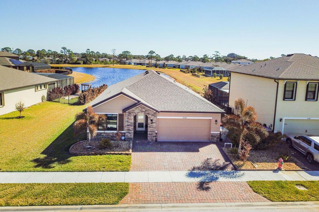 An aerial view of a single-story suburban house with a stone facade and paved driveway — 6560 Canterbridge Drive, Vero Beach FL 32967, VERO BEACH, FL