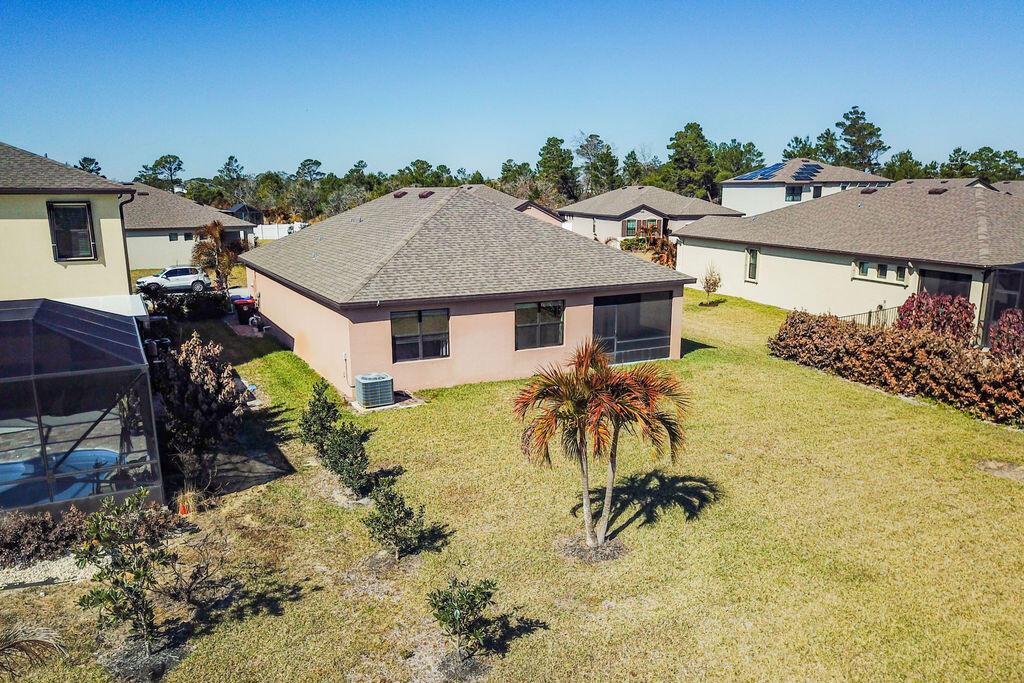 An aerial view of a suburban house with a backyard, palm tree, and screened patio — 6560 Canterbridge Drive, Vero Beach FL 32967, VERO BEACH, FL