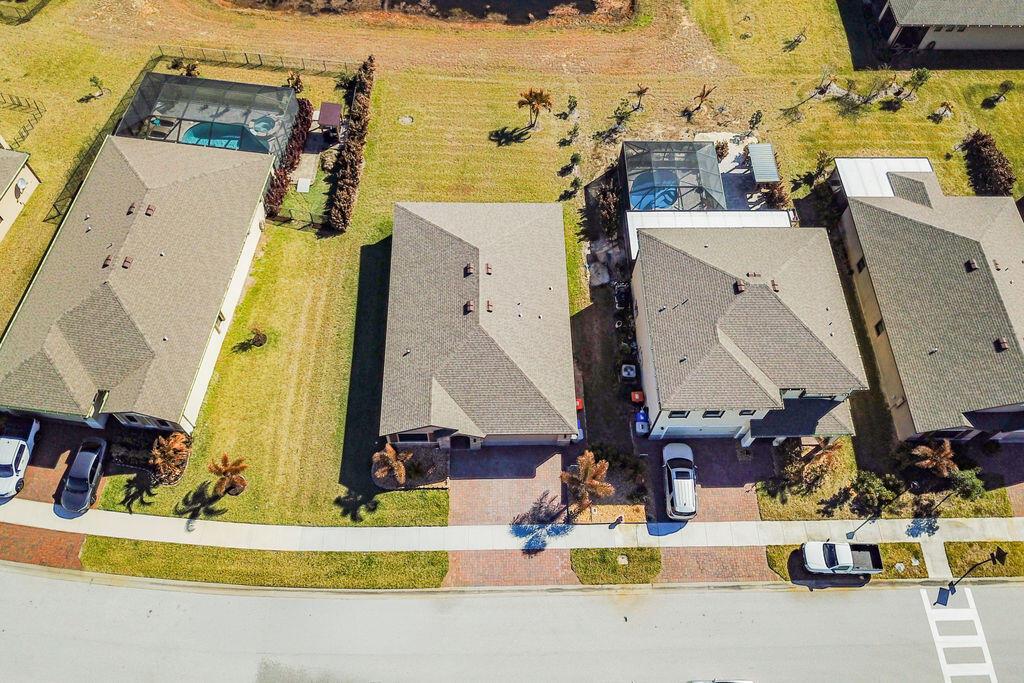 An aerial view shows four suburban houses with driveways, pools, and lawns along a street — 6560 Canterbridge Drive, Vero Beach FL 32967, VERO BEACH, FL