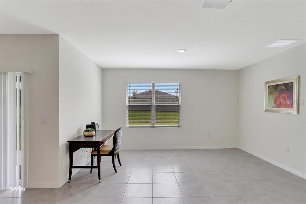 A bright, tiled room features a desk, a chair, a window, and wall art — 937 CATTLEMAN STREET, WINTER HAVEN, FL