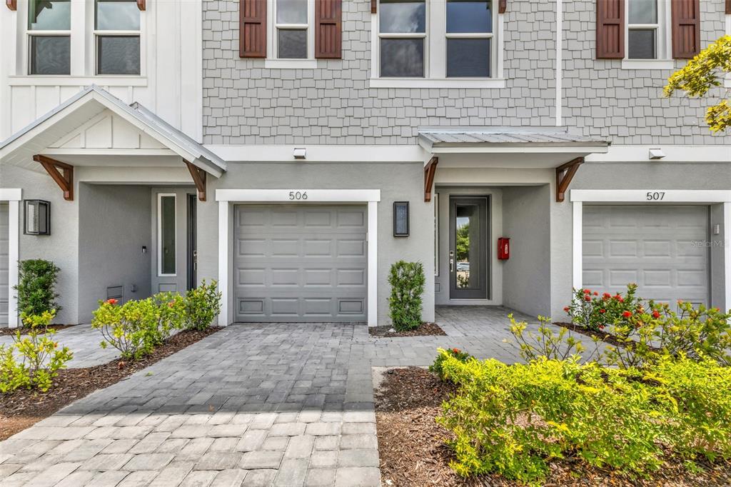 The exterior of two adjacent townhomes features gray siding, shingled accents, and paved driveways — 1617 SEAHAVEN DRIVE UNIT 506, PUNTA GORDA, FL