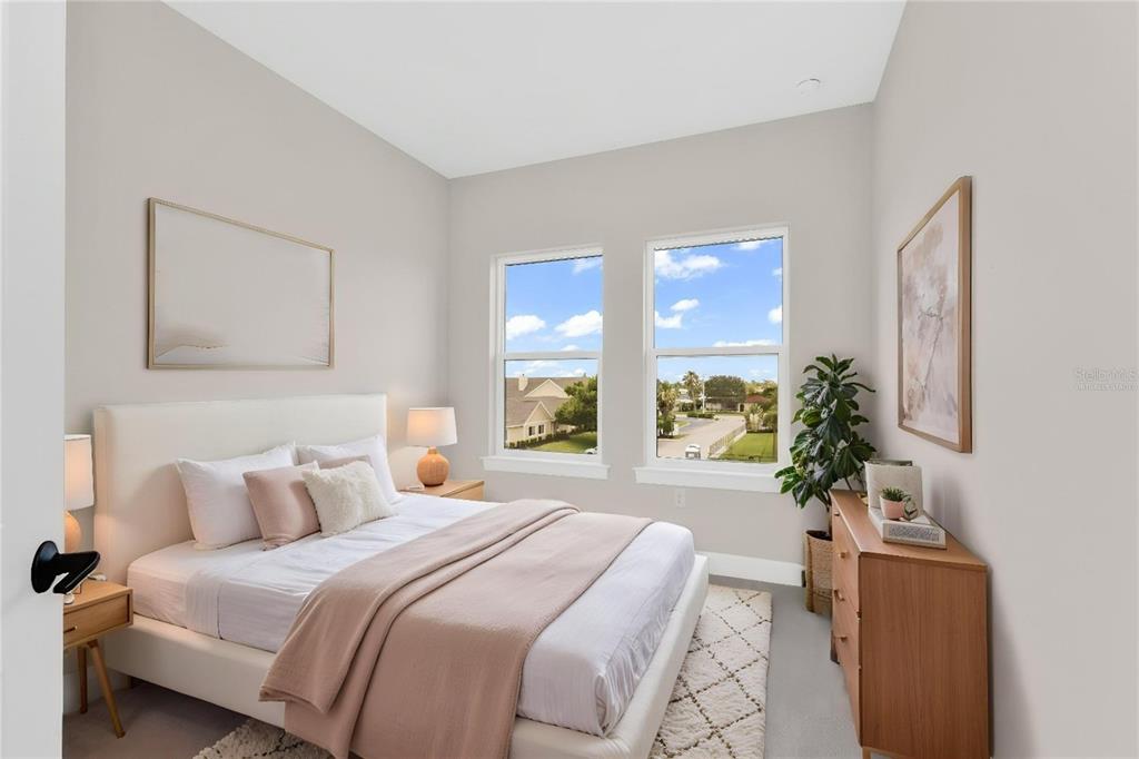 A bedroom features a bed with neutral bedding, two windows, and a wooden dresser — 1617 SEAHAVEN DRIVE UNIT 506, PUNTA GORDA, FL