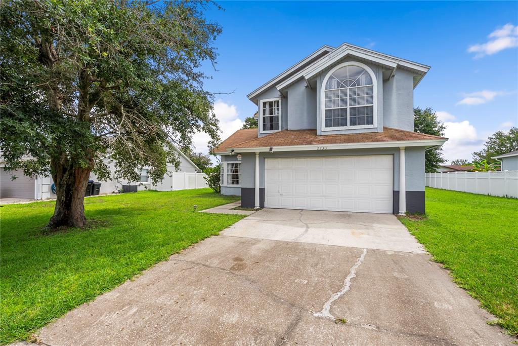 A two-story house with a gray exterior, a white garage door, and a concrete driveway — 2233 ARDON AVENUE, ORLANDO, FL
