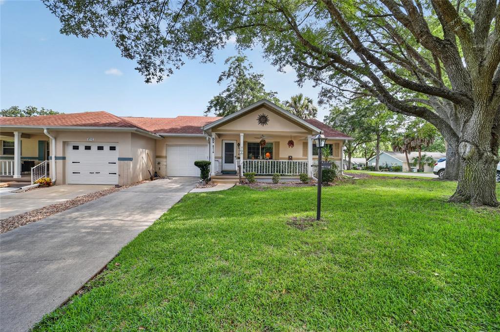 A single-story house with a tan exterior, a front porch, and a concrete driveway — 8711 SW 96TH LANE UNIT D, OCALA, FL