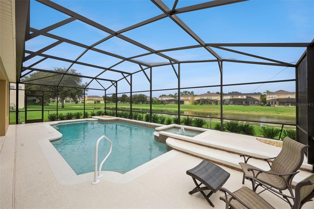 A screened-in patio features a swimming pool, a raised spa, and views of a pond — 11942 SHELTERING PINE DRIVE, ORLANDO, FL
