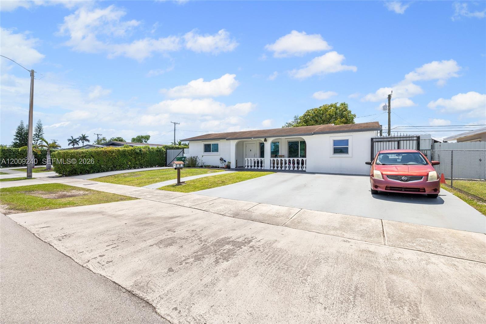 A single-story white house with a concrete driveway and a red car parked outside — 11810 SW 172nd St, Miami FL 33177, MIAMI, FL