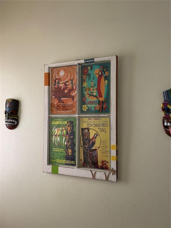 A wall displays a vintage window frame containing four Enchanted Tiki Room posters between two masks — 2348 SILVER PALM DRIVE, KISSIMMEE, FL