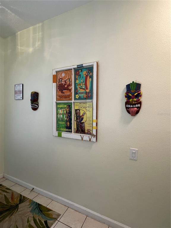 A wall features a window frame displaying four Tiki-themed prints flanked by two decorative masks — 2348 SILVER PALM DRIVE, KISSIMMEE, FL