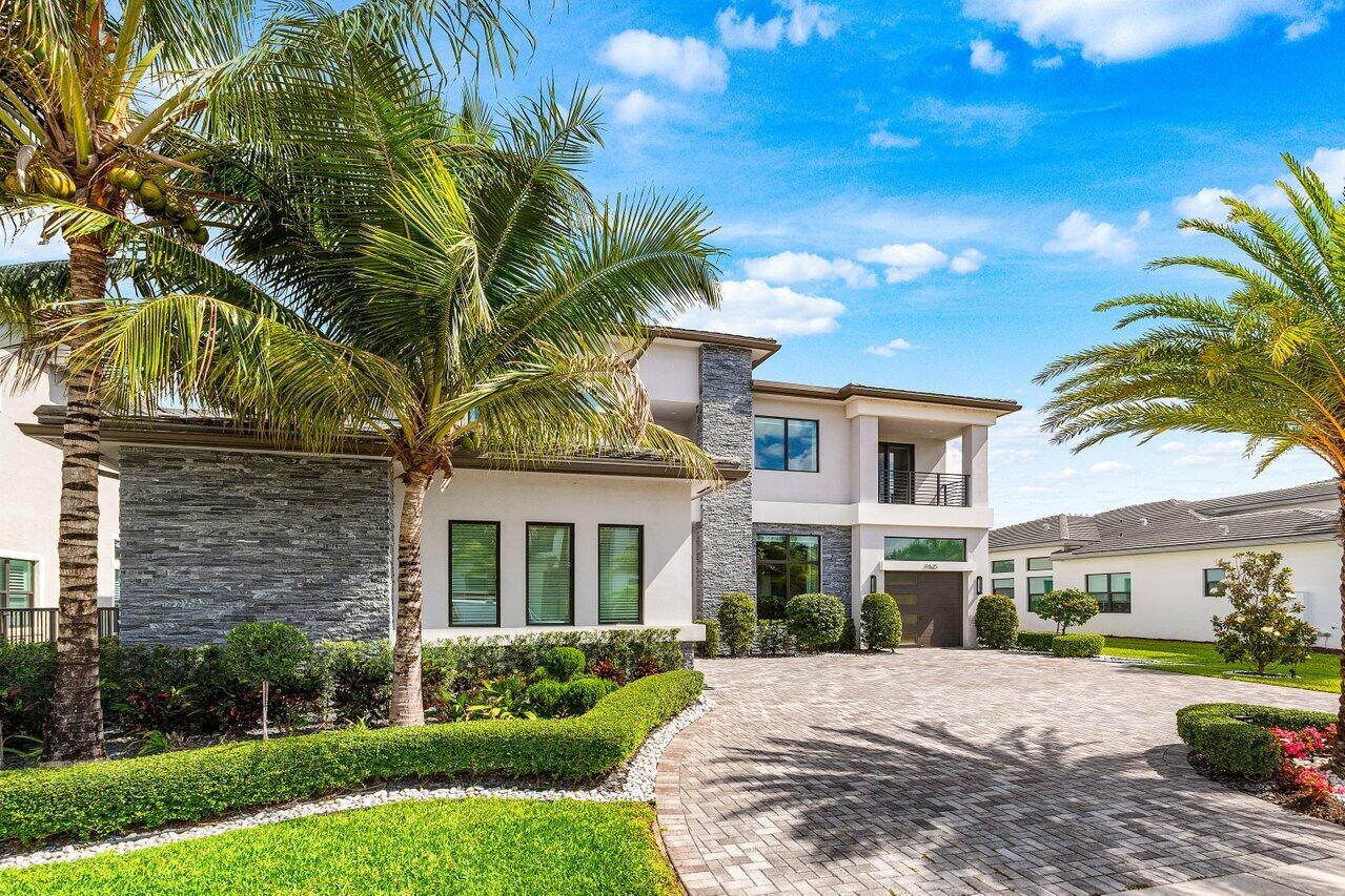 A two-story modern house with stone accents, a paver driveway, and palm trees in front — 9625 Vescovato Way, Boca Raton FL 33496, BOCA RATON, FL