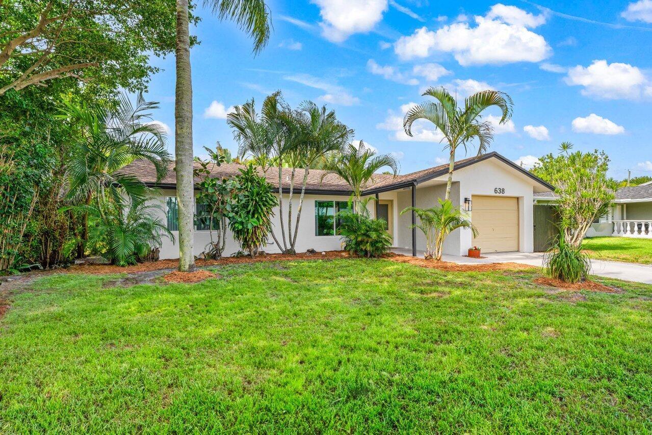 A single-story house with a tan garage, white exterior, and palm trees in the front yard — 638 SW 4th Avenue, Boynton Beach FL 33426, BOYNTON BEACH, FL