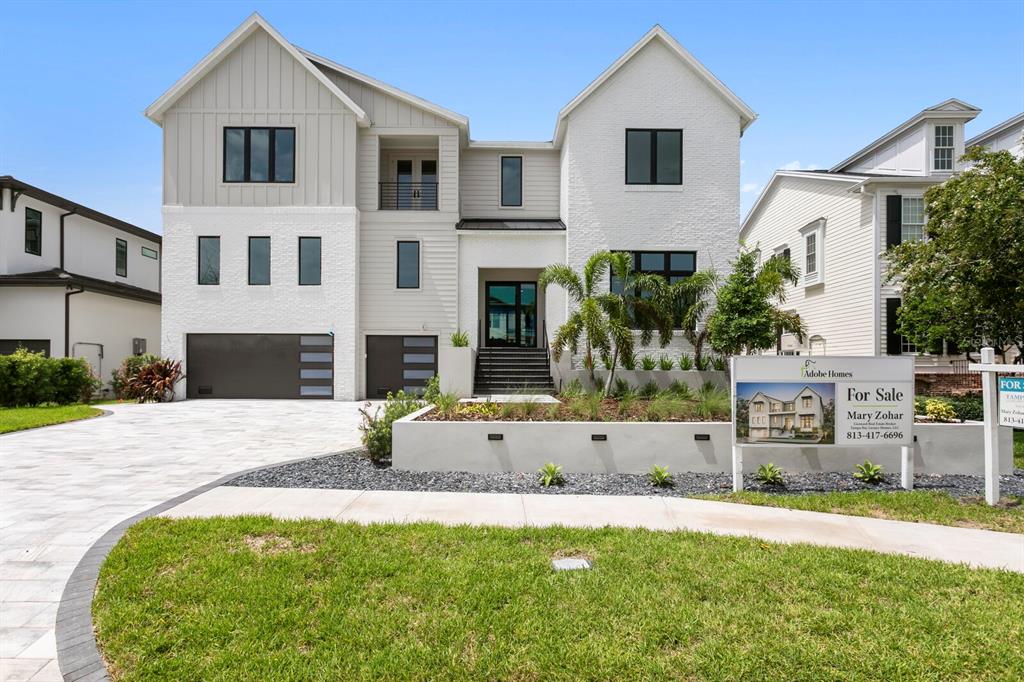 A modern two-story house with white brick, gray siding, and a paved driveway — 5023 W DANTE AVENUE, TAMPA, FL