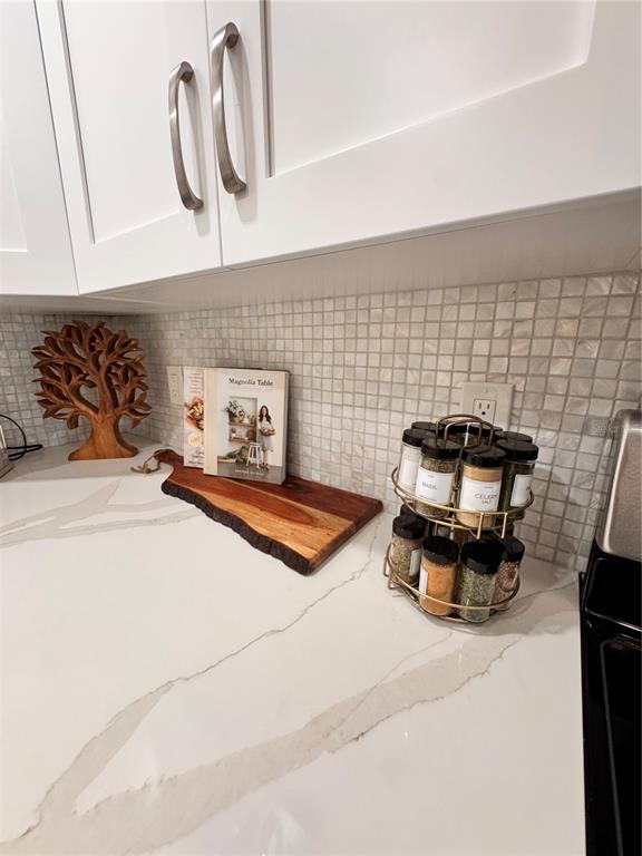 A kitchen counter features a white marble countertop, a wooden cutting board, and a spice rack — 5623 MIDNIGHT PASS ROAD UNIT 615, SIESTA KEY, FL