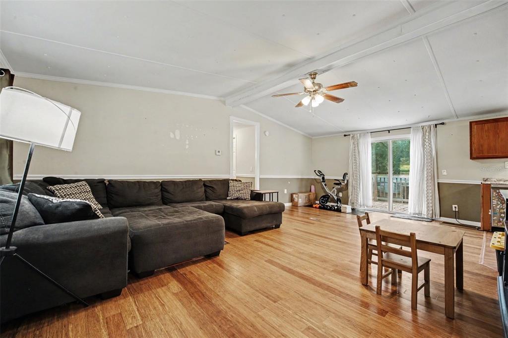 A single-story manufactured home with a covered front porch sits on a wooded lot — 173 PLANKTON AVENUE, MIDDLEBURG, FL