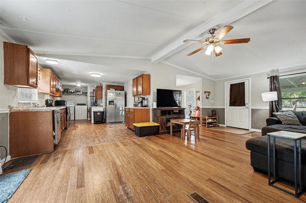 A living room features hardwood floors, a gray sectional sofa, and an exercise bike — 173 PLANKTON AVENUE, MIDDLEBURG, FL