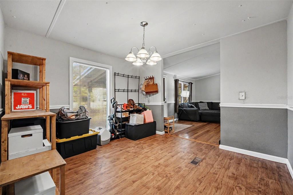 A living room with hardwood floors, a large sectional sofa, and a dining table — 173 PLANKTON AVENUE, MIDDLEBURG, FL