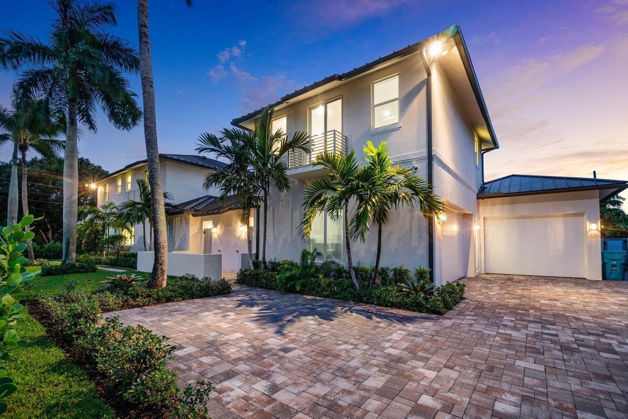 A two-story house with a paved driveway, palm trees, and a white garage at dusk — 217 Gulfstream Boulevard, Boynton Beach FL 33435, BOYNTON BEACH, FL