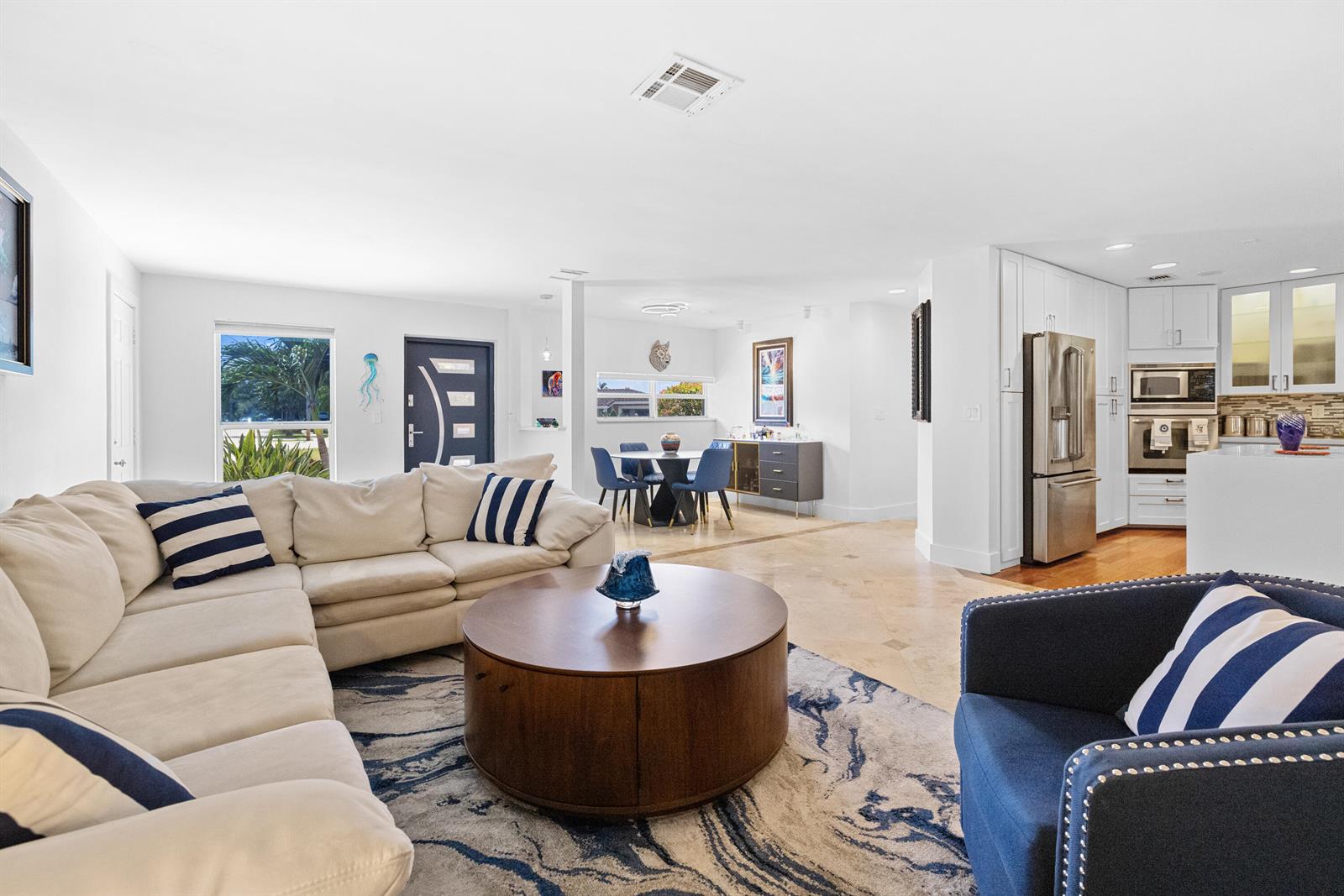An open-concept living room features a sectional sofa, round coffee table, and adjacent dining area — 5041 NE 24th Avenue, Lighthouse Point FL 33064, LIGHTHOUSE POINT, FL