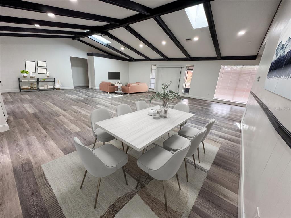 A dining area with a white table and chairs sits in a large, open-concept room — 3810 SE 22ND PLACE, OCALA, FL